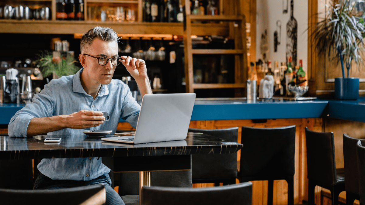 Restauranteigenaar werkt aan laptop in de zaak